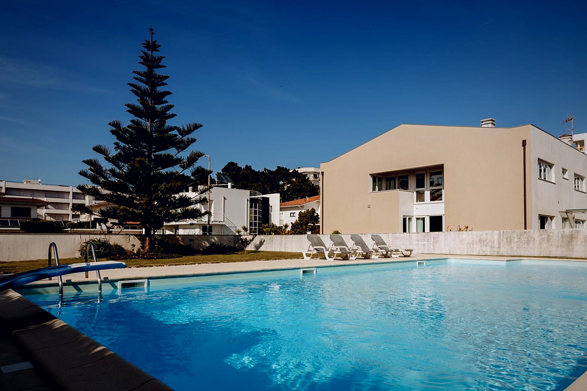 Piscina privada e jardim da Viana Beach & Surf House ao entardecer