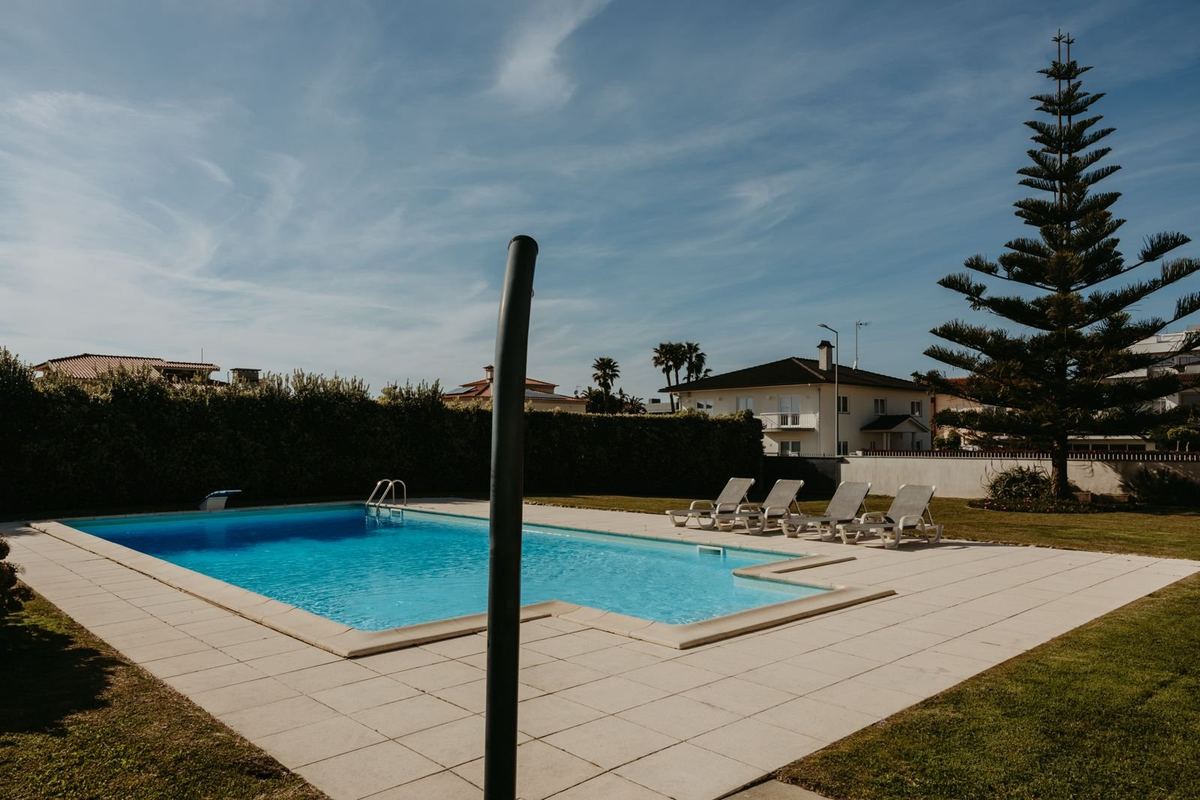 Piscina privada da moradia com espreguiçadeiras e jardim