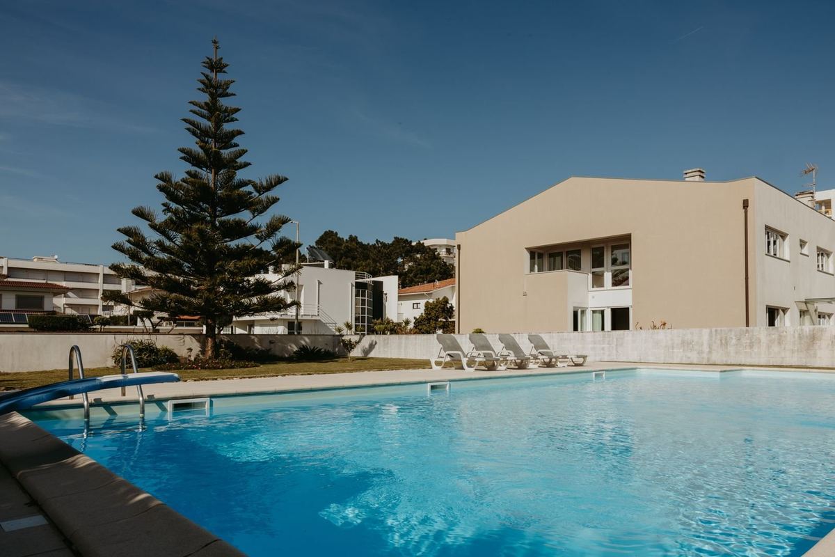 Piscina privada da moradia com espreguiçadeiras e jardim