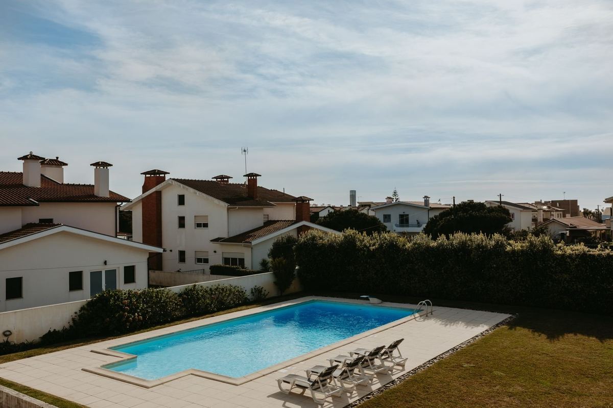 Piscina privada da moradia com espreguiçadeiras e jardim