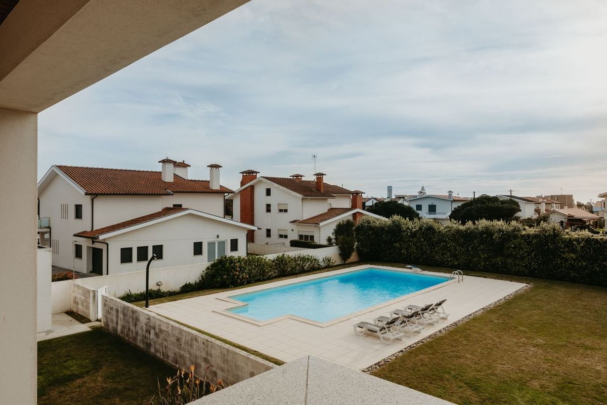 Piscina privada da moradia com espreguiçadeiras e jardim