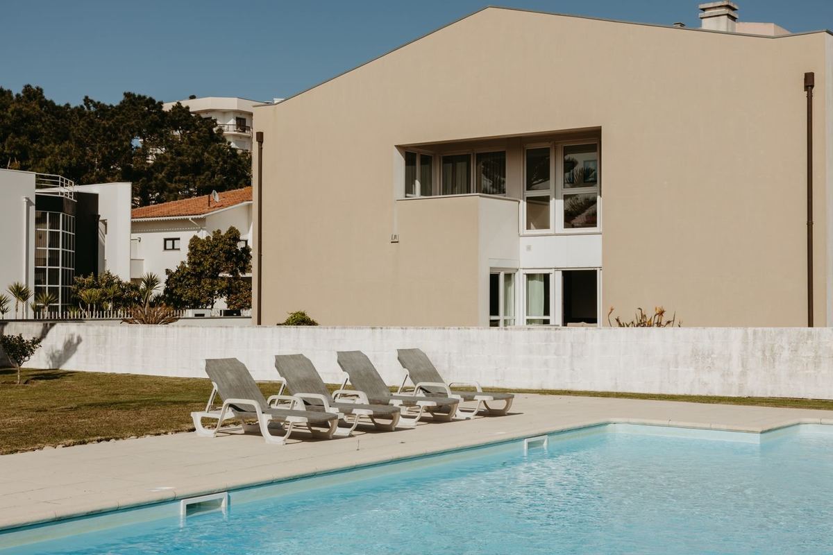 Piscina privada da moradia com espreguiçadeiras e jardim