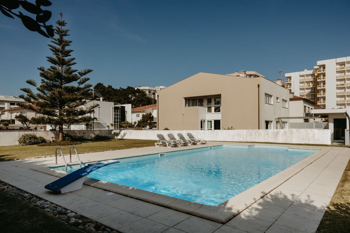 Piscina privada da moradia com espreguiçadeiras e jardim