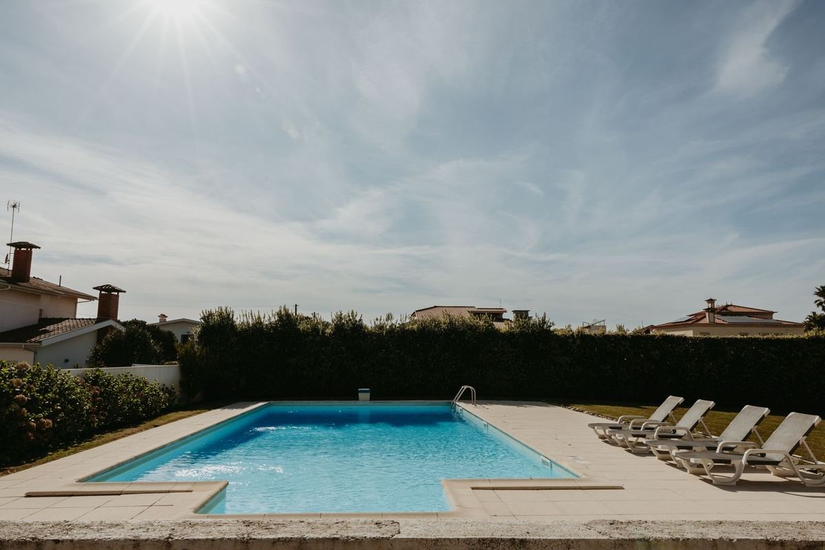 Piscina privada da moradia com espreguiçadeiras e jardim