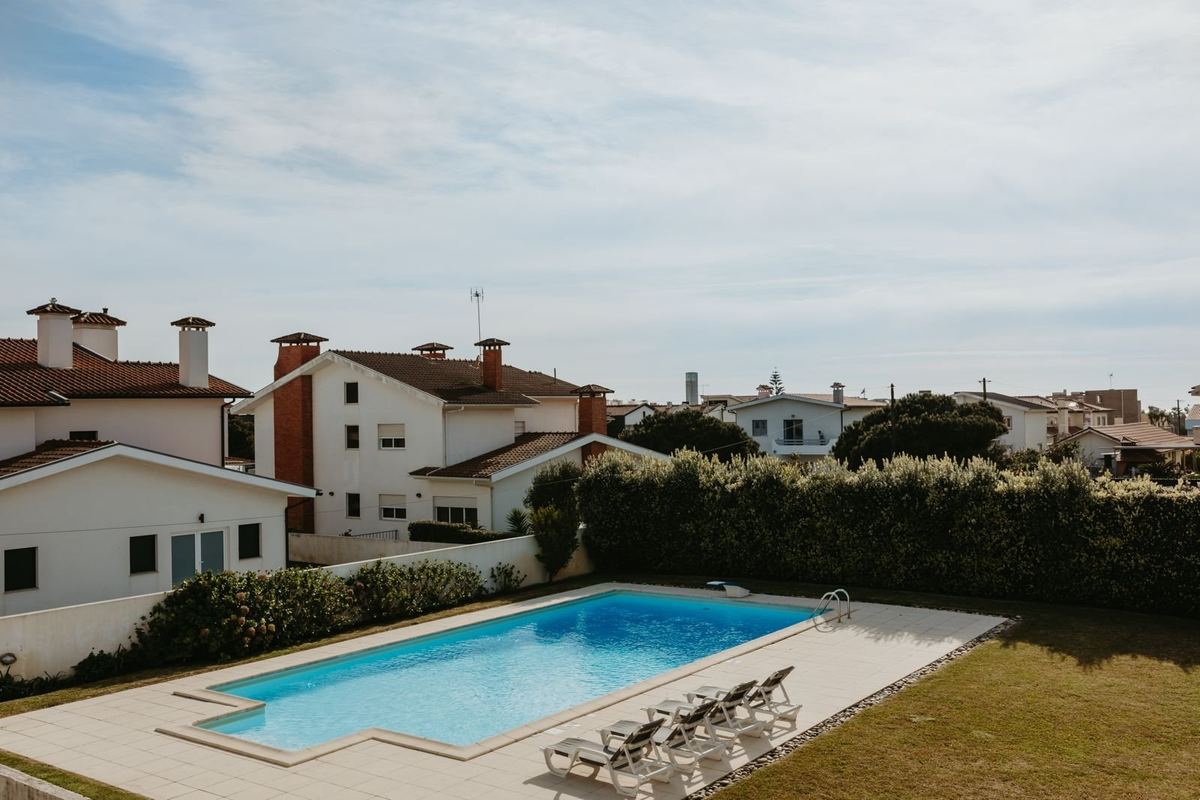 Piscina privada da moradia com espreguiçadeiras e jardim