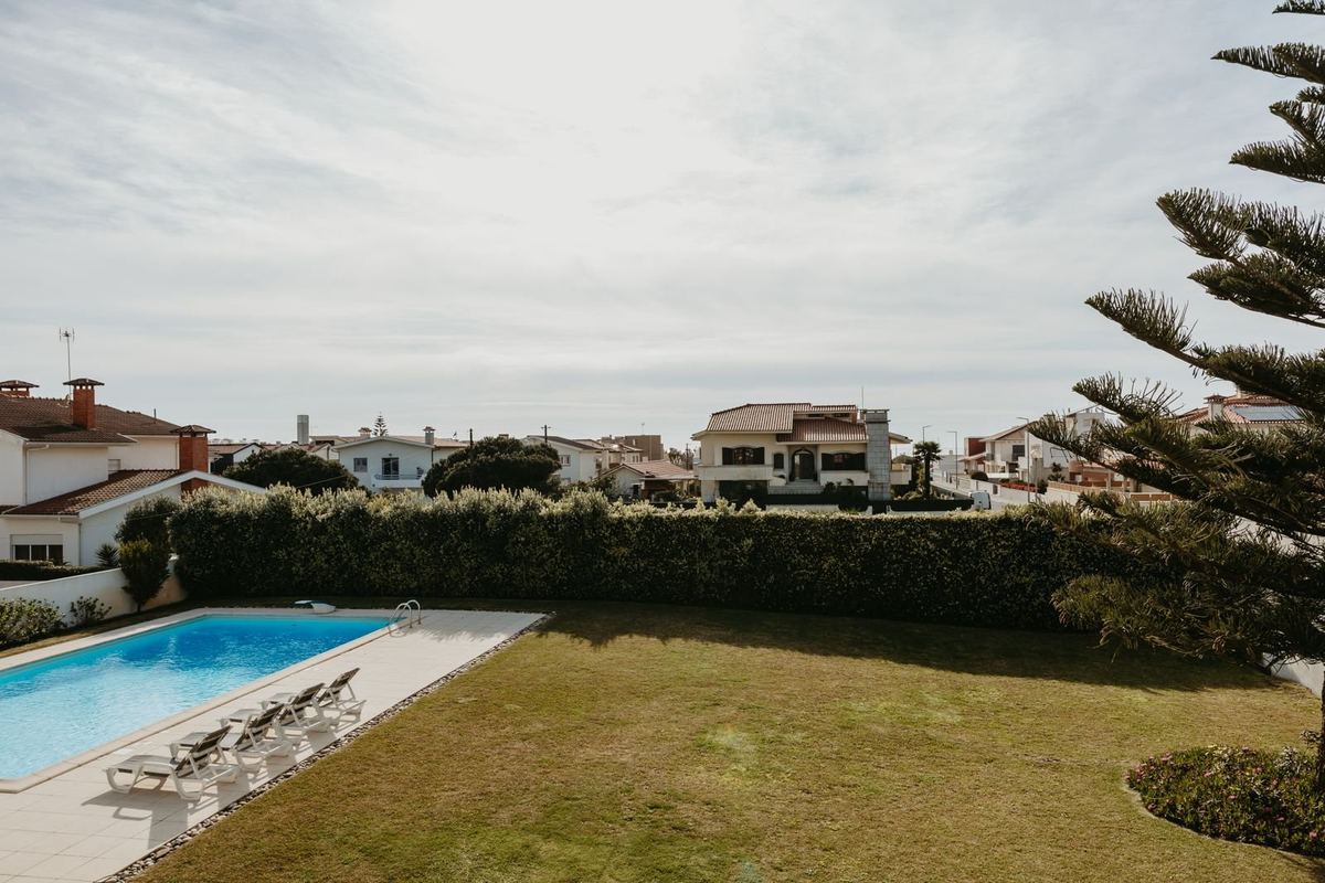 Piscina privada da moradia com espreguiçadeiras e jardim