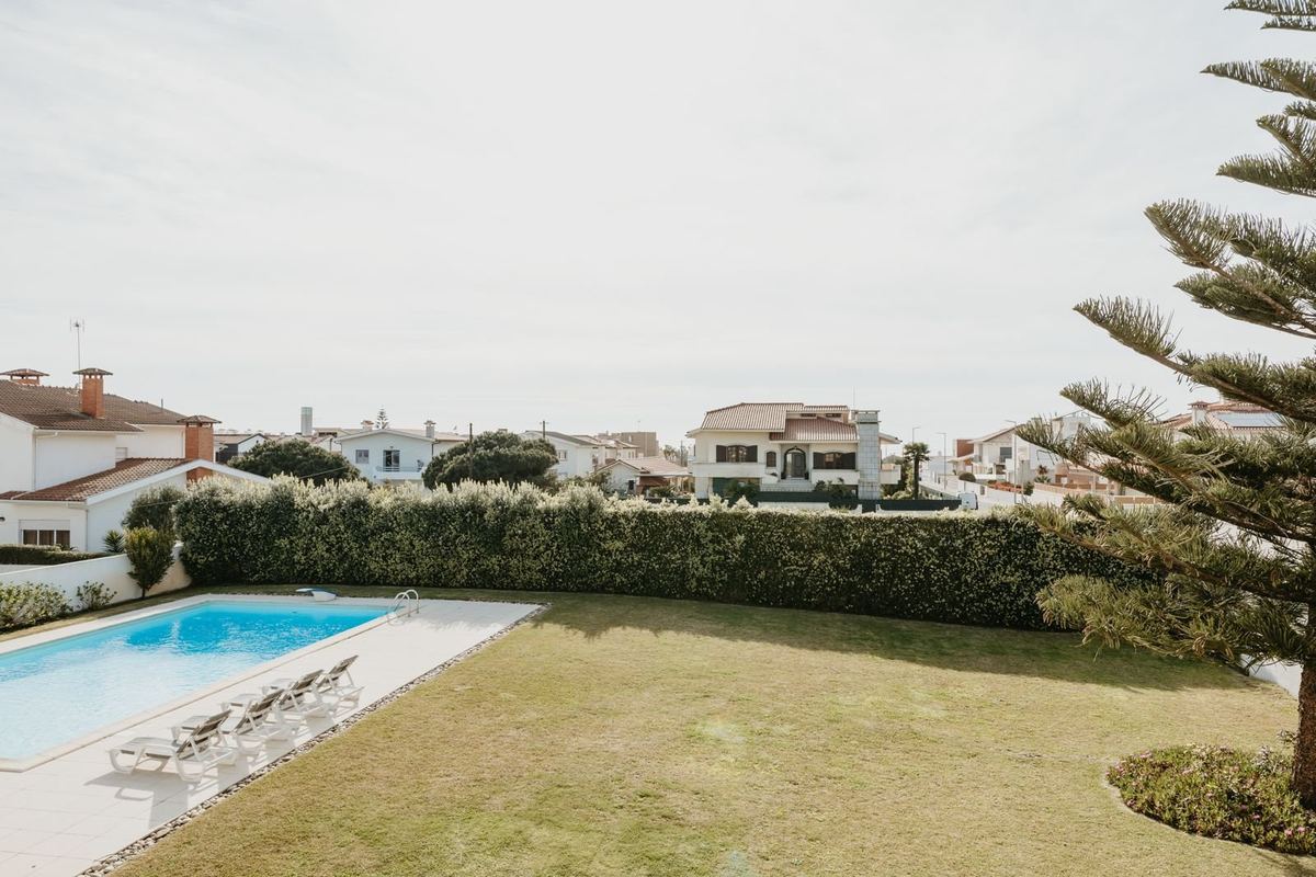 Piscina privada da moradia com espreguiçadeiras e jardim