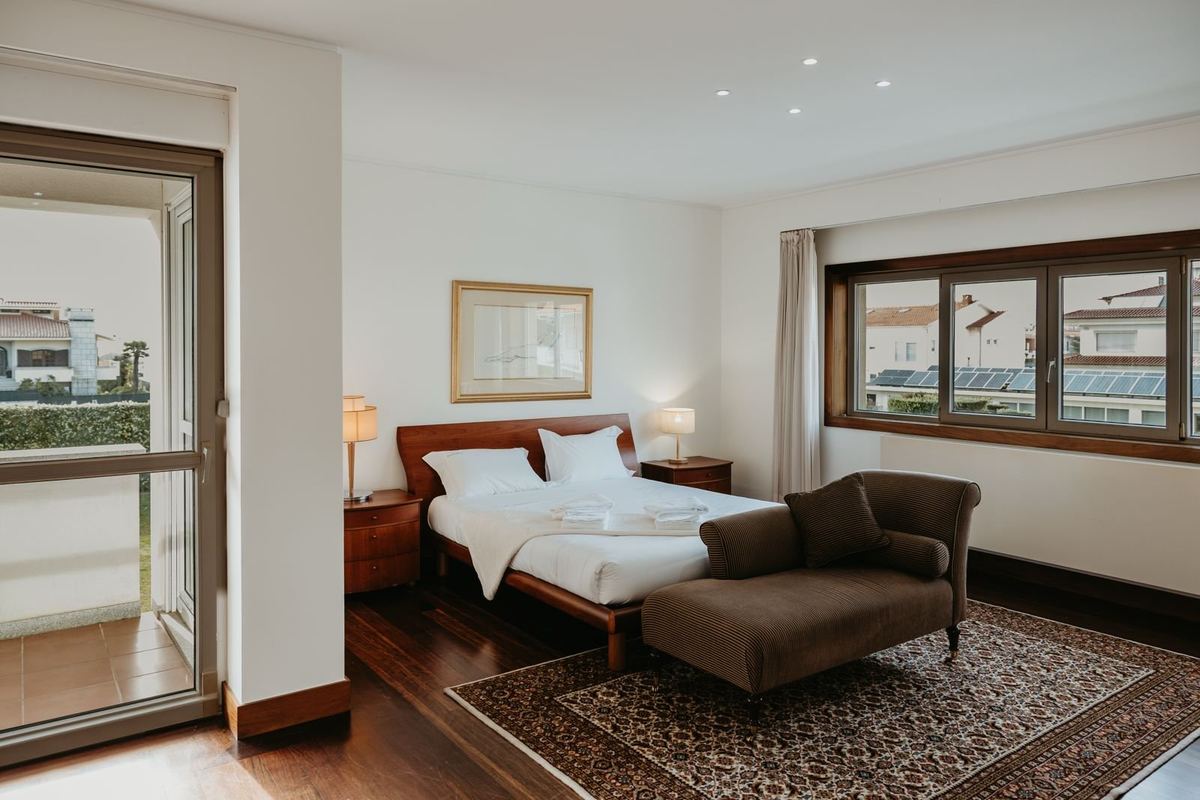 Quarto da moradia com cama preparada e roupa de cama branca