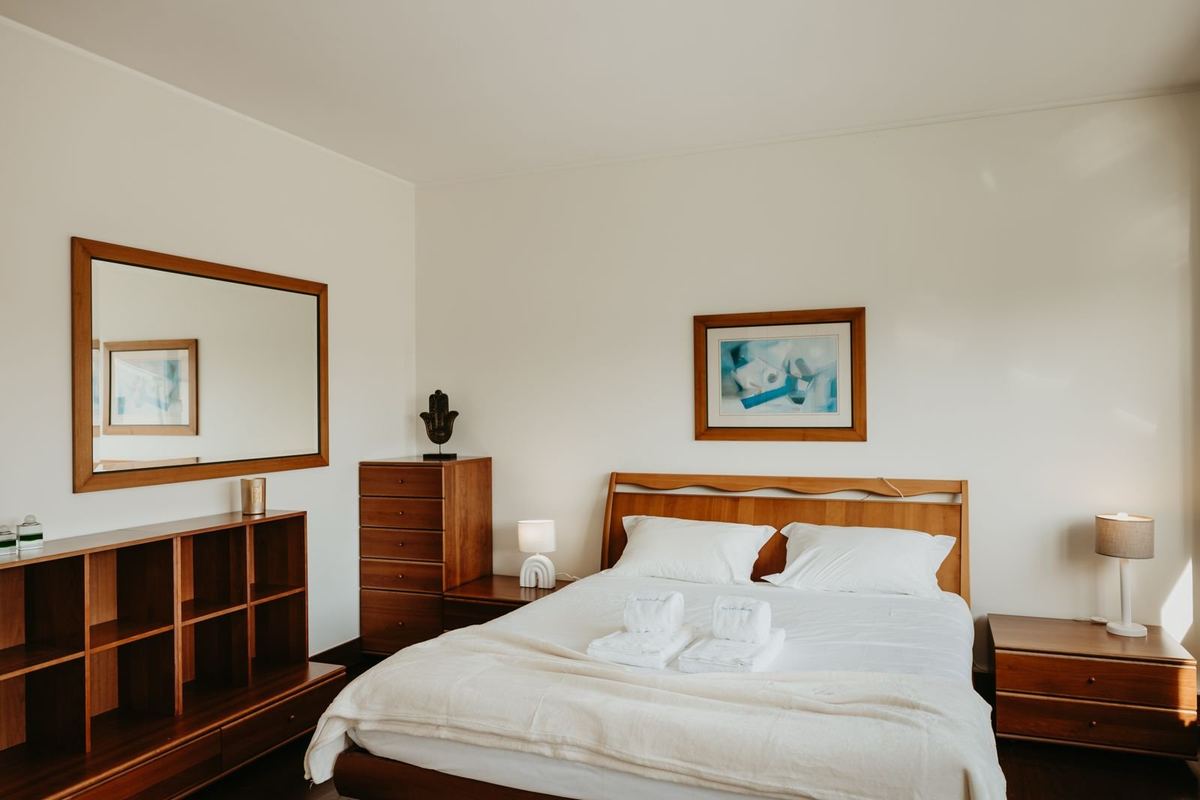 Quarto da moradia com cama preparada e roupa de cama branca
