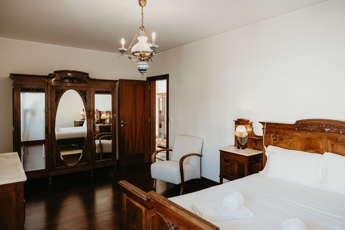 Quarto da moradia com cama preparada e roupa de cama branca